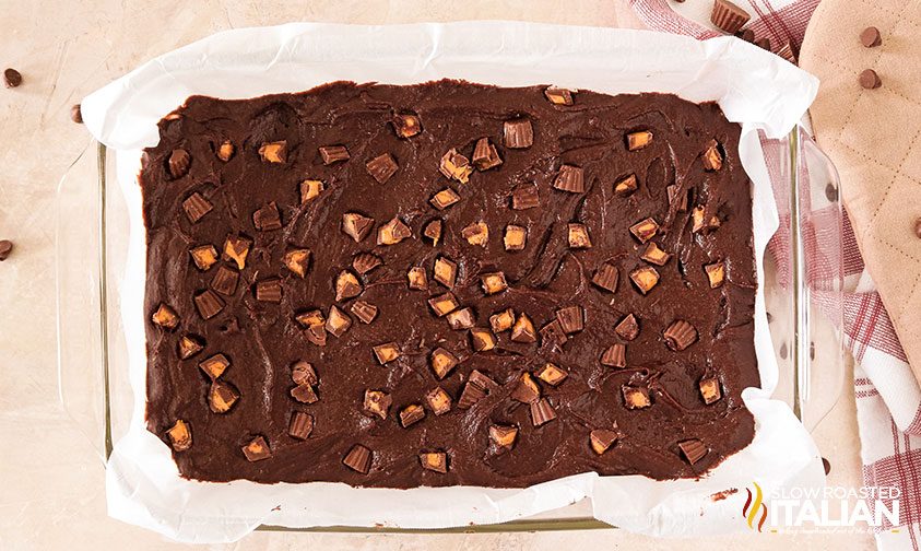 reese's cups in brownie batter spread into baking pan