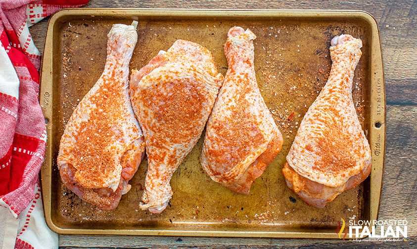 turkey legs coated with dry rub on sheet pan