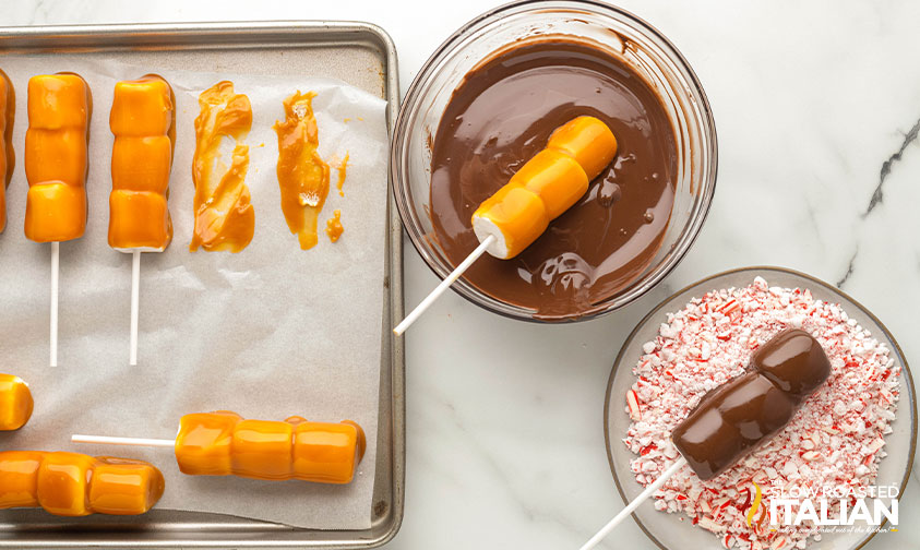 dipping caramel covered marshmallows in chocolate and rolling in crushed peppermints