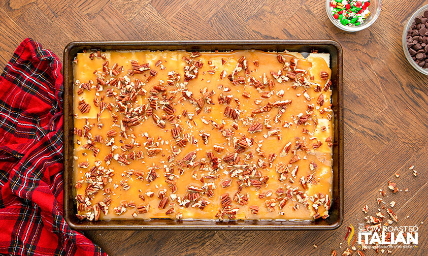 adding chopped pecan to salted caramel bars