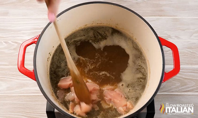 adding chicken breasts to pot