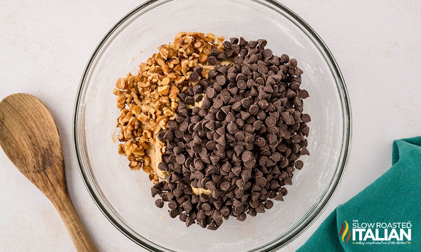 adding chocolate chips and walnuts to cookie dough