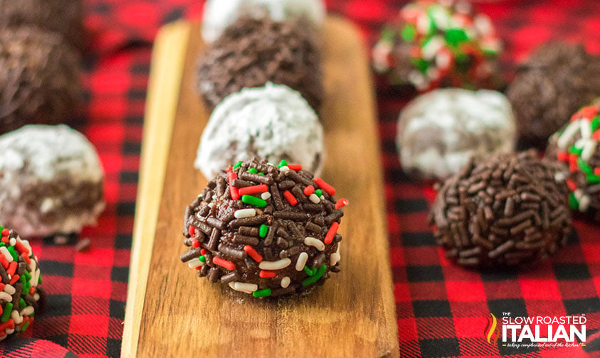 boozy rum balls covered in powdered sugar and festive sprinkles