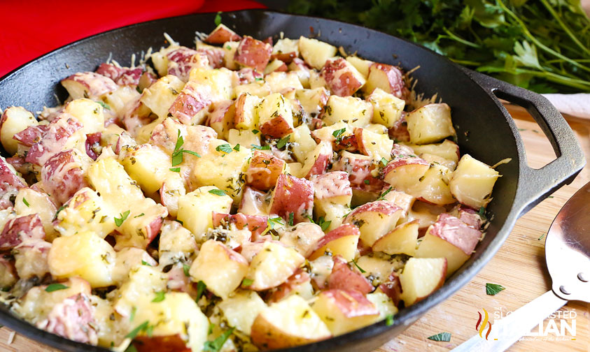 cheesy garlic parmesan potatoes in a skillet