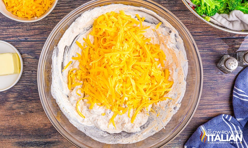 adding grated cheese to sour cream and soup mixture