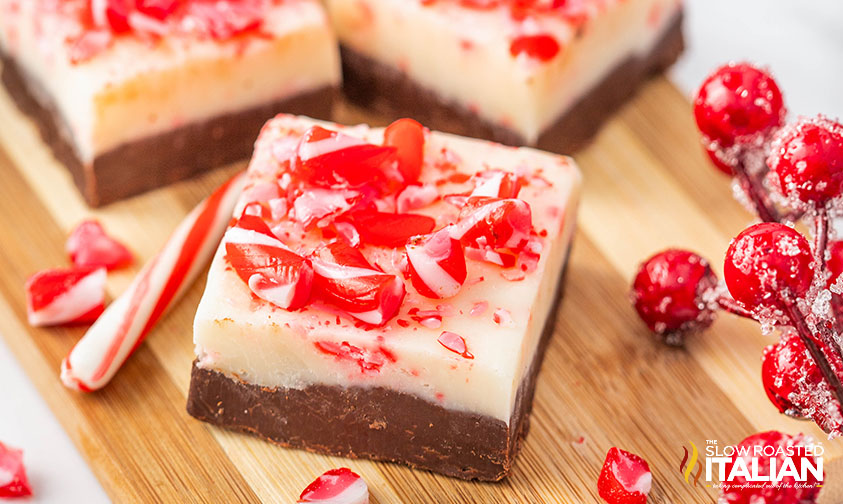 peppermint bark fudge with candy canes on a wood board