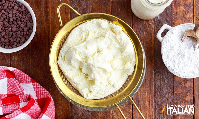 draining ricotta in fine mesh sieve over a bowl