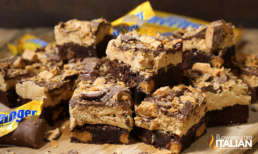 stacked butterfinger brownies on a wood board