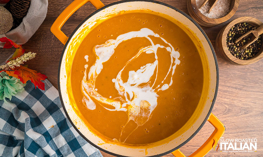 stirring cream into autumn squash soup
