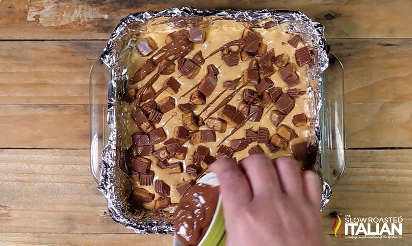 adding chopped reese's and chocolate drizzle to fudge