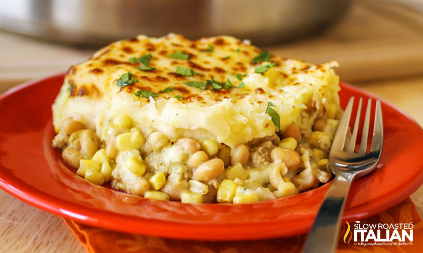 tuscan chicken shepherd's pie on a red plate with fork