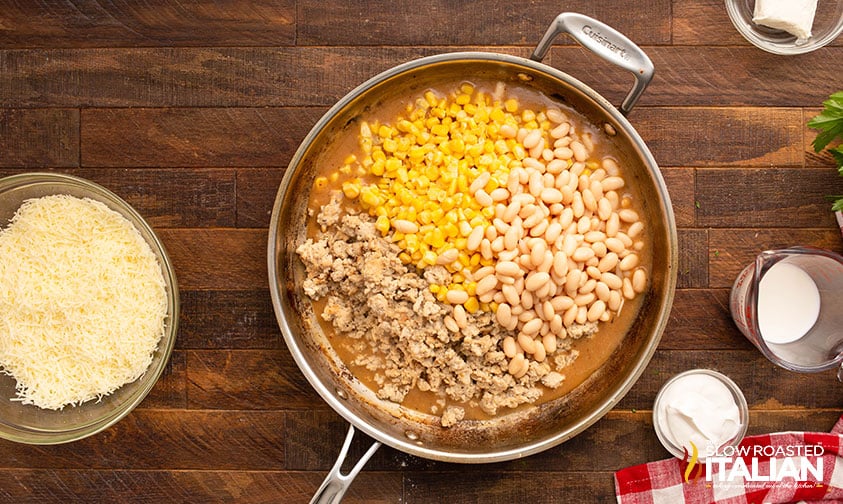 adding beans, and corn to the skilled with ground chicken