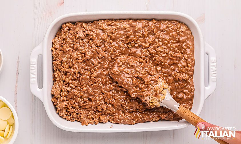 spreading chocolate rice cereal mixture into baking pan