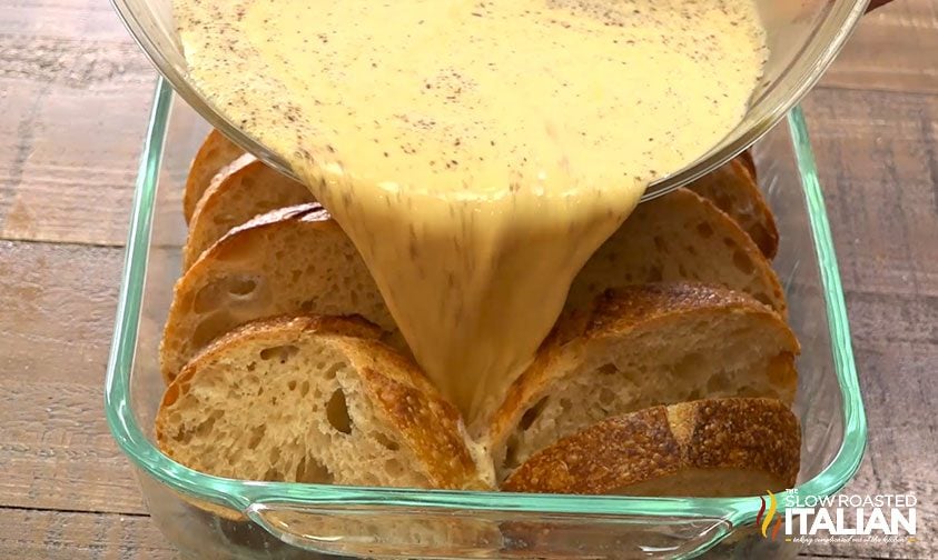 pouring custard mixture over french bread in baking dish