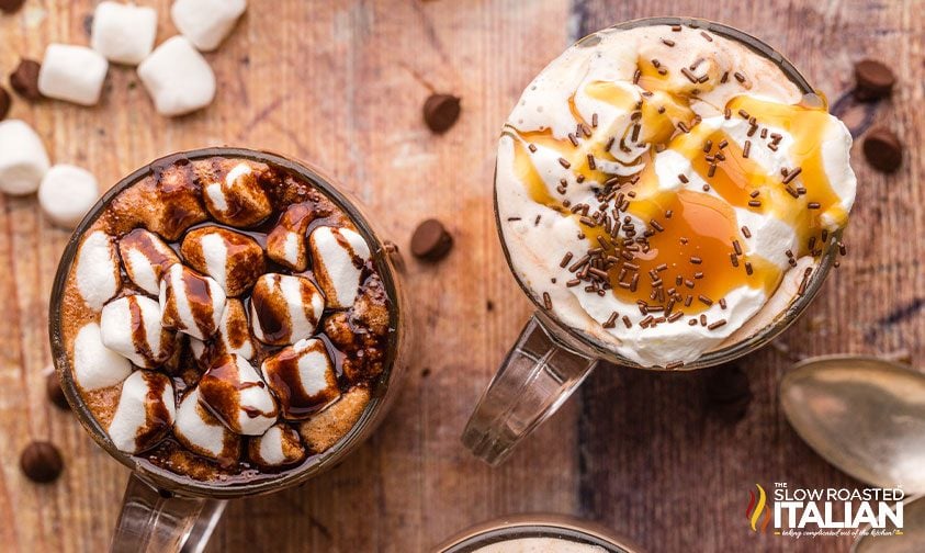 overhead: two clear mugs of cocoa with different toppings