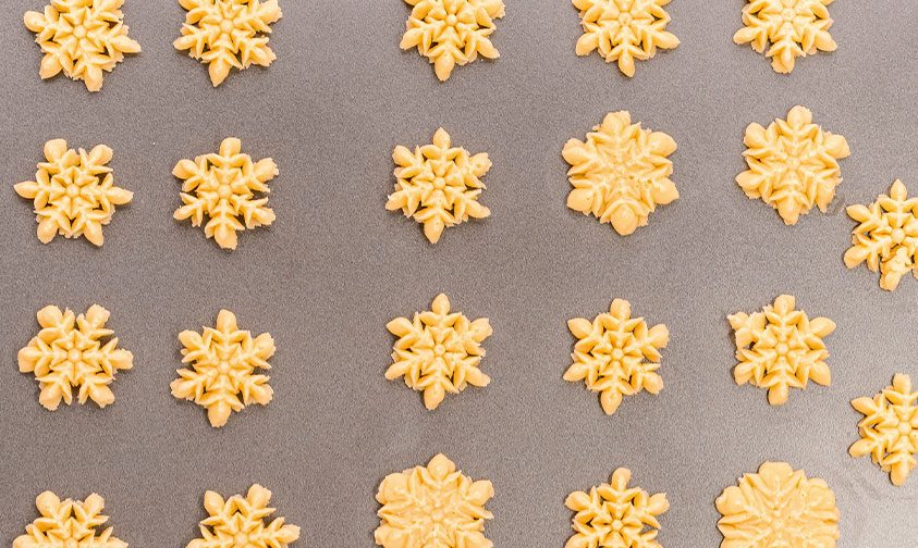 pressed snowflake cookies on baking sheet