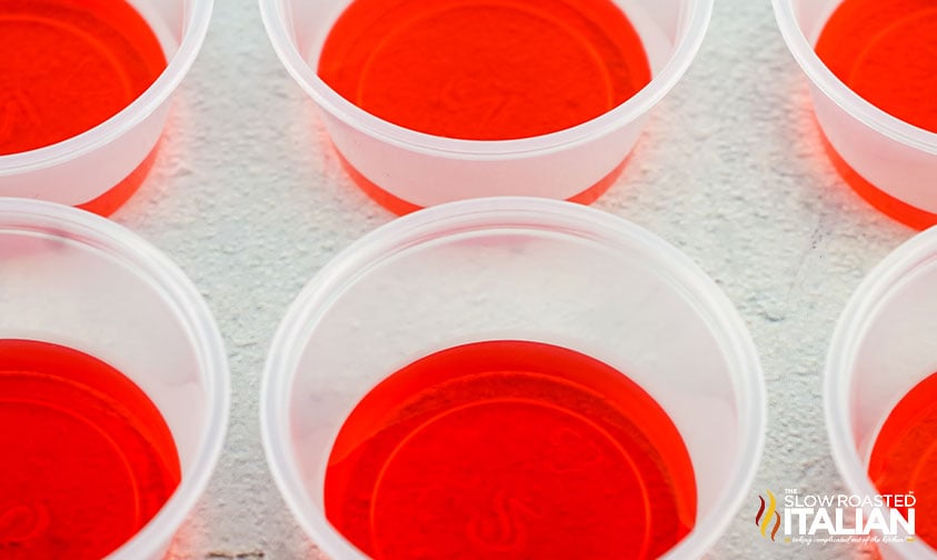 a layer of red jello in plastic shot cups