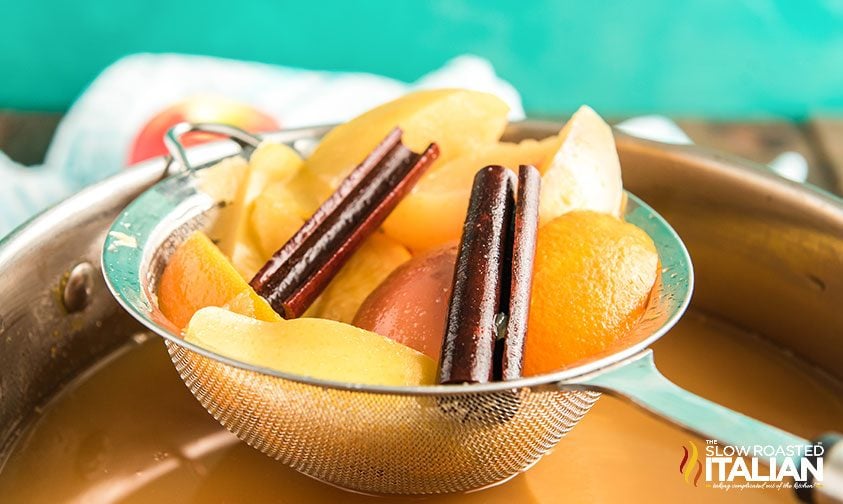 straining fruit and spices out of cider 