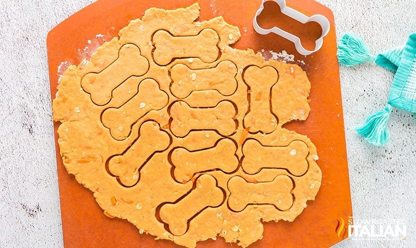 rolled out dog treat dough cut into bone shapes