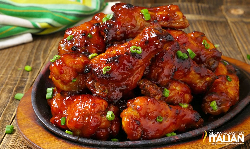 plate of honey bbq wings topped with green onions