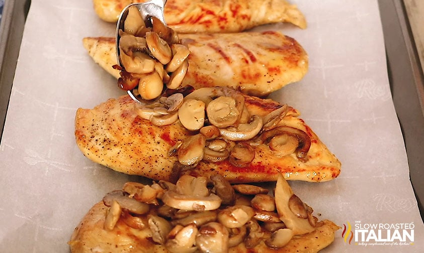 spooning mushrooms onto chicken