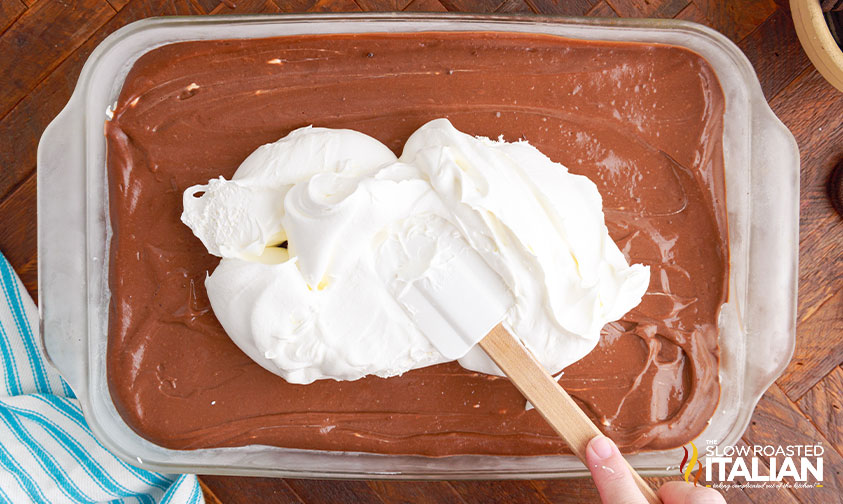 adding topping to oreo dessert