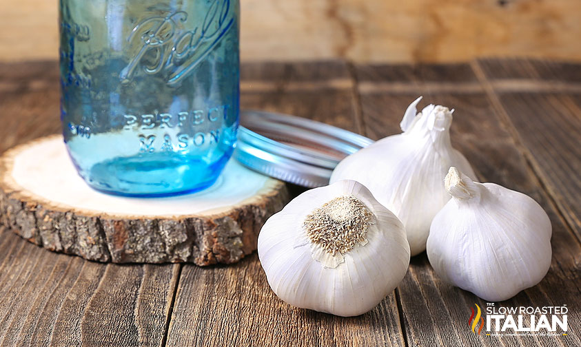 cloves of garlic next to a jar