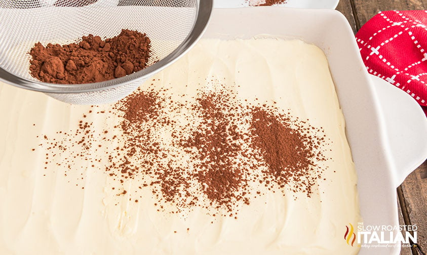 sprinkling cocoa powder on top of olive garden tiramisu