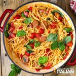 top view of cheesy pasta and sausage in a red pot