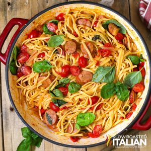 top view of cheesy pasta and sausage in a red pot