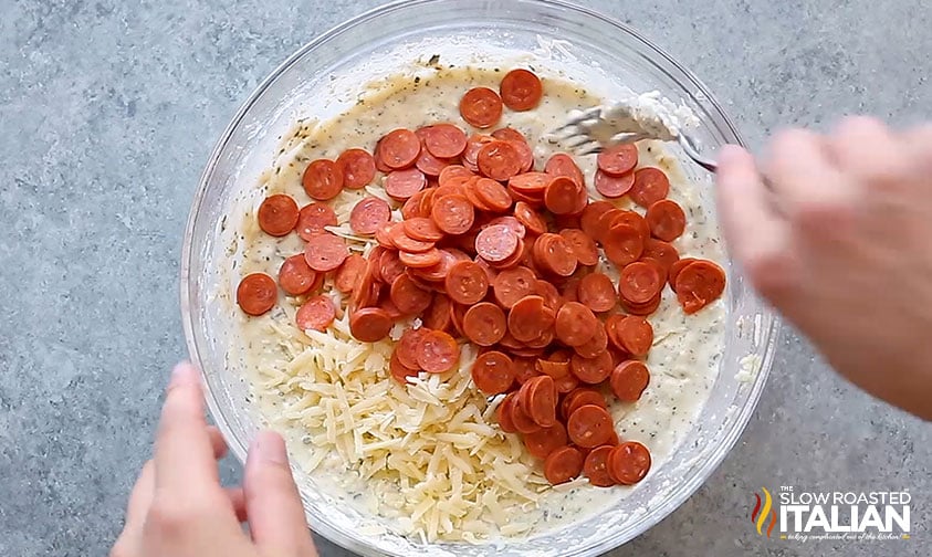 adding pepperoni and cheese to pizza bites recipe