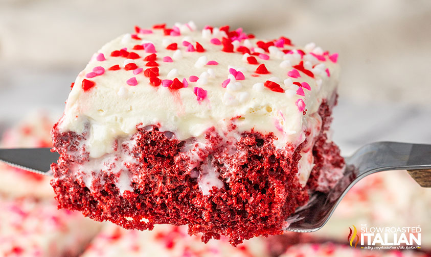 slice of red velvet poke cake on a serving knife