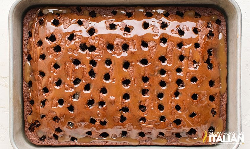pan of chocolate cake with holes poked all over