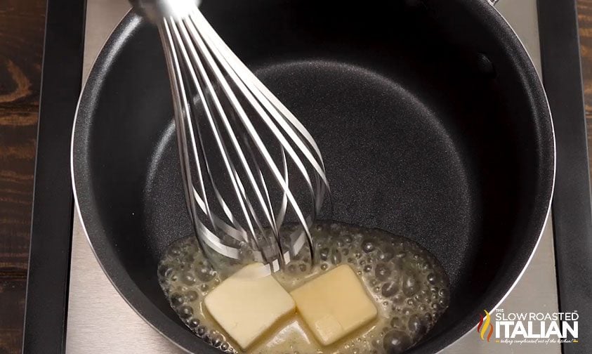 whisking butter as it melts in saucepan