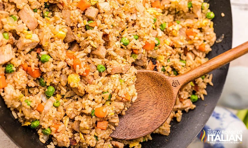 spoon in skillet of fried rice with pork