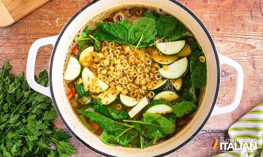 spinach, pasta, and zucchini added to minestrone soup pot