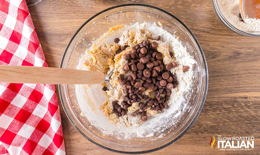 adding chocolate chips to cookie dough