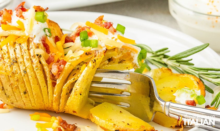 cutting a hasselback potato with a fork