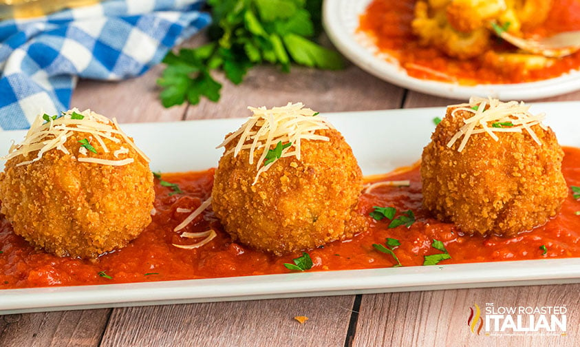 mac and cheese bites in marinara on a serving tray