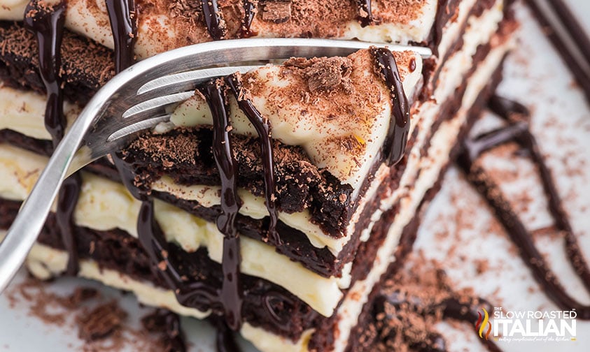 close up of a fork slicing through chocolate brownie lasagna