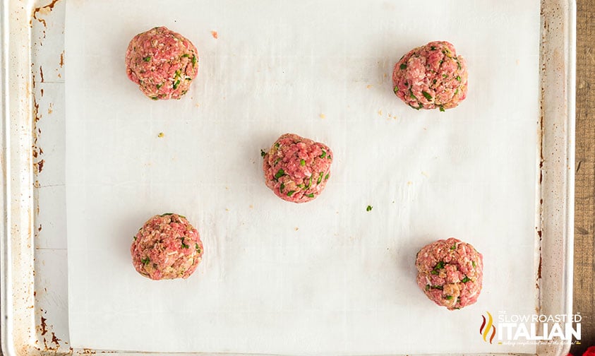 shaped meatballs on a parchment lined baking sheet