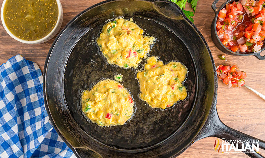frying sweet corn tamale cakes in a cast iron skillet