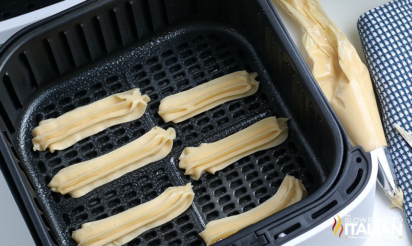 churro dough piped into air fryer basket