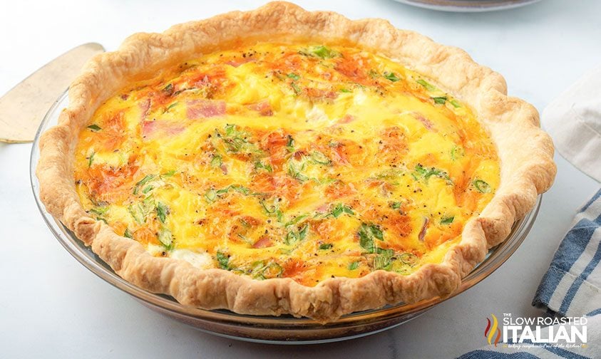baked ham and cheese quiche in clear pie plate