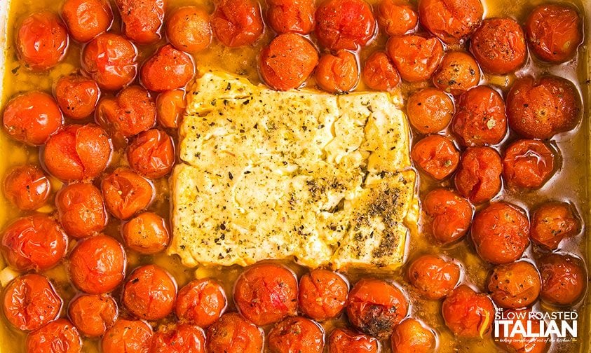 block of feta nestled in cherry tomatoes, baked