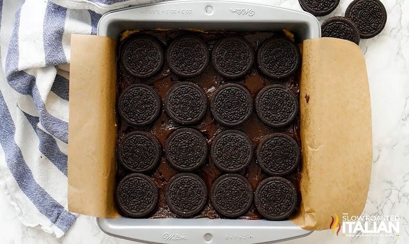 oreo cookies on top of brownie batter in parchment lined pan