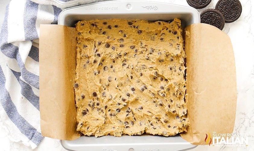 chocolate chip cookie dough in parchment lined square pan