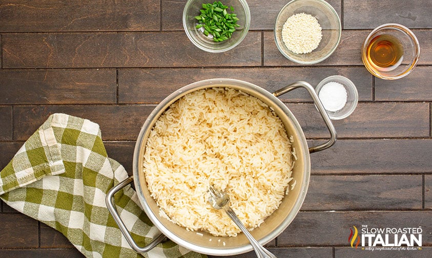 fluffing cooked jasmine rice with a fork