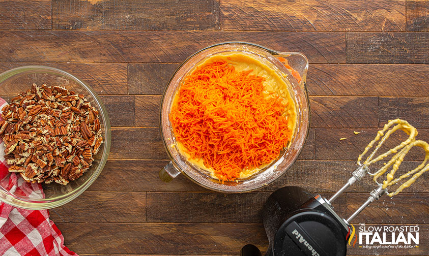 adding shredded carrots to carrot cake batter