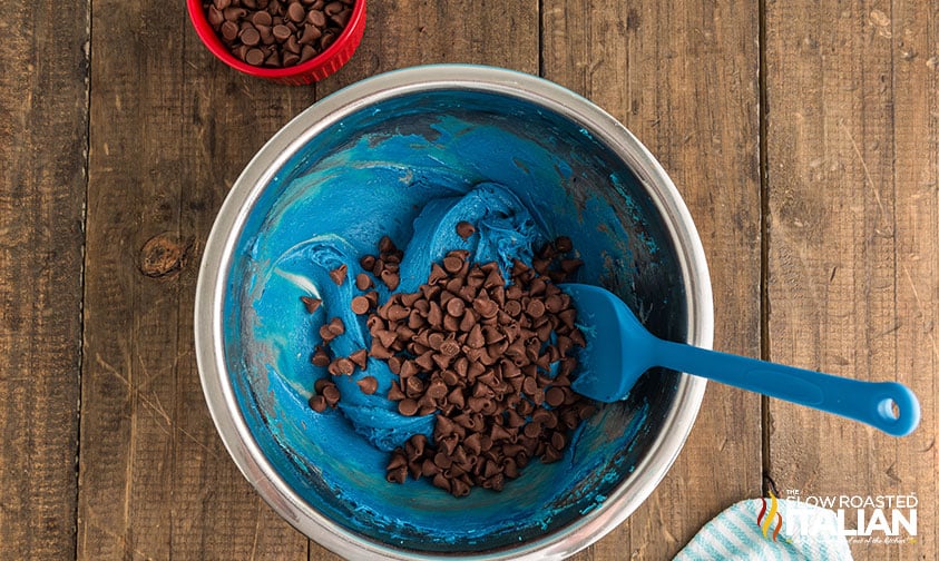 adding chocolate chips to blue chocolate chip cookies dough